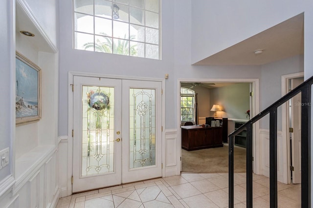 334 N Shadowbay Blvd, Longwood, FL 32779 - entrance foyer featuring a towering ceiling, light carpet, light tile patterned floors, a wainscoted wall, and a ceiling fan