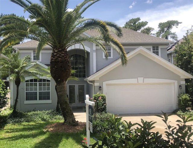 334 N Shadowbay Blvd, Longwood, FL 32779 - view of front of house featuring french doors, stucco siding, an attached garage, a shingled roof, and driveway
