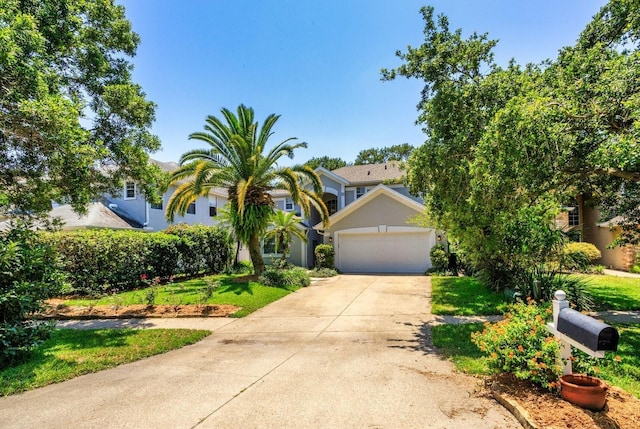 334 N Shadowbay Blvd, Longwood, FL 32779 - view of property hidden behind natural elements featuring driveway, stucco siding, a garage, and a front lawn