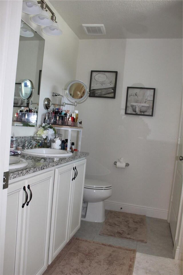 5897 Soter Ln, Windermere, FL 34786 - bathroom with toilet, tile patterned flooring, a textured ceiling, and vanity