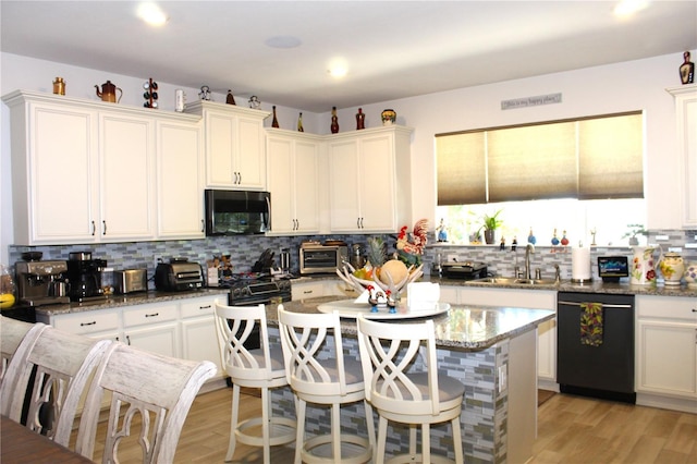 5897 Soter Ln, Windermere, FL 34786 - kitchen featuring black dishwasher, backsplash, a sink, a kitchen breakfast bar, and a center island