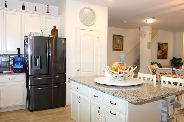 5897 Soter Ln, Windermere, FL 34786 - kitchen with stainless steel refrigerator with ice dispenser, light stone countertops, white cabinets, and a center island