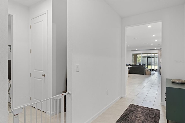 hall featuring recessed lighting, light tile patterned floors, and baseboards