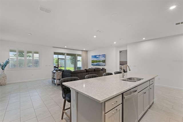 kitchen with a sink, stainless steel dishwasher, open floor plan, light tile patterned floors, and recessed lighting