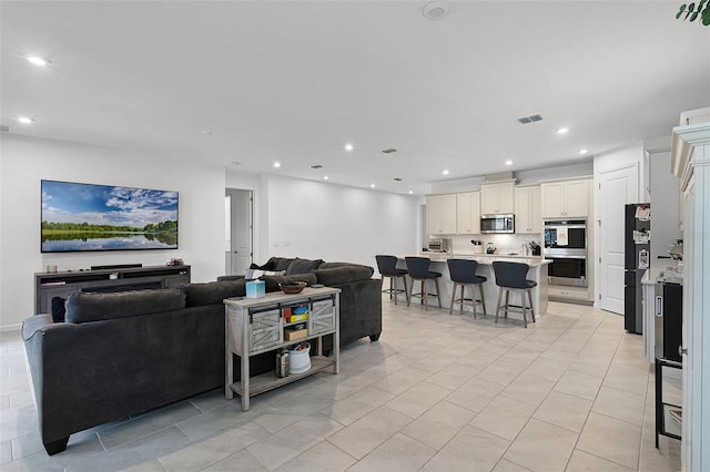 living room with recessed lighting and light tile patterned floors