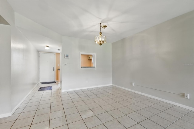1415 Doolittle Ln Unit 106, Dunedin, FL 34698 - empty room with a chandelier, light tile patterned flooring, and baseboards