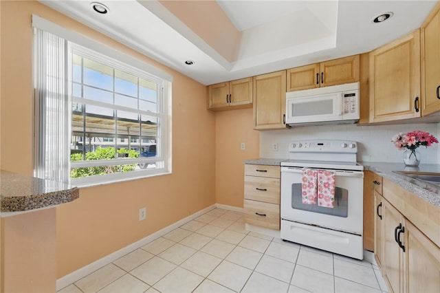 1415 Doolittle Ln Unit 106, Dunedin, FL 34698 - kitchen featuring white appliances, light brown cabinets, light stone countertops, a raised ceiling, and tasteful backsplash