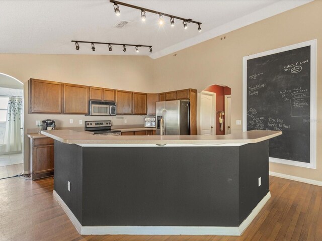 10247 Mason Loop, Clermont, FL 34711 - kitchen with appliances with stainless steel finishes, arched walkways, brown cabinets, light countertops, and high vaulted ceiling