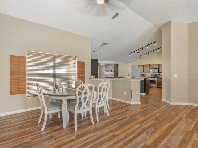 10247 Mason Loop, Clermont, FL 34711 - dining area with track lighting, vaulted ceiling, a ceiling fan, light wood-style flooring, and baseboards