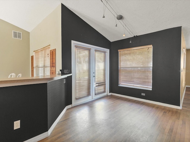 10247 Mason Loop, Clermont, FL 34711 - unfurnished room featuring lofted ceiling, wood finished floors, baseboards, track lighting, and a textured ceiling