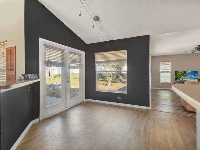 10247 Mason Loop, Clermont, FL 34711 - unfurnished dining area featuring wood finished floors, lofted ceiling, baseboards, ceiling fan, and track lighting