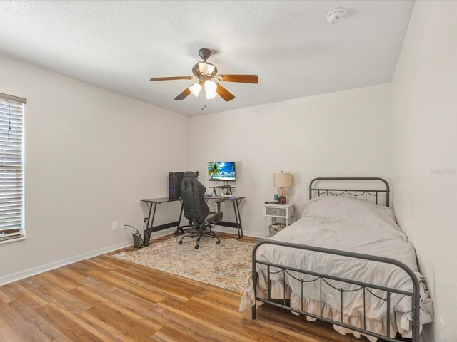 10247 Mason Loop, Clermont, FL 34711 - bedroom featuring wood finished floors, a desk, baseboards, a ceiling fan, and a textured ceiling