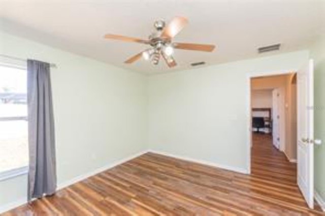 10247 Mason Loop, Clermont, FL 34711 - empty room featuring healthy amount of natural light, wood finished floors, ceiling fan, and baseboards