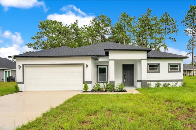 prairie-style home with stucco siding, driveway, a garage, a front yard, and roof with shingles