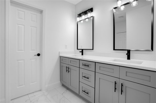 full bathroom featuring marble look tile flooring, baseboards, and double vanity