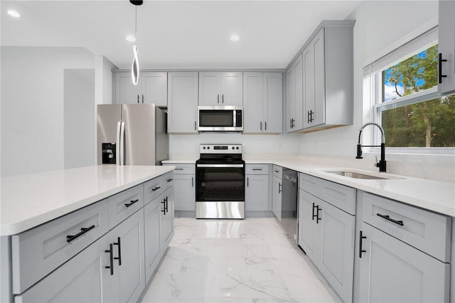 kitchen with stainless steel appliances, gray cabinetry, a sink, light marble finish floors, and recessed lighting
