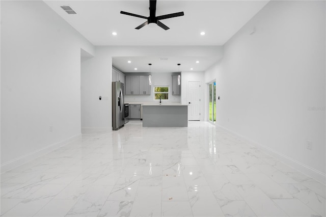unfurnished living room with baseboards, ceiling fan, recessed lighting, a sink, and light marble finish flooring