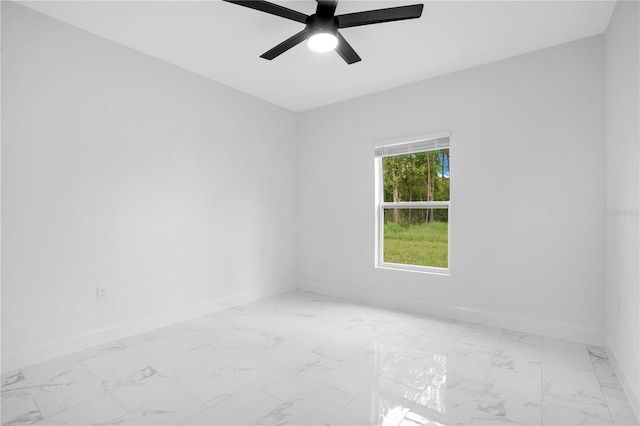 unfurnished room featuring light marble finish flooring and baseboards