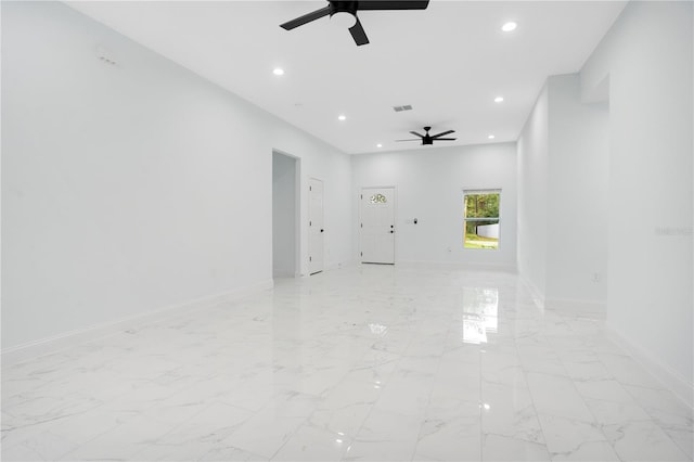 unfurnished room featuring ceiling fan, recessed lighting, light marble finish floors, and baseboards