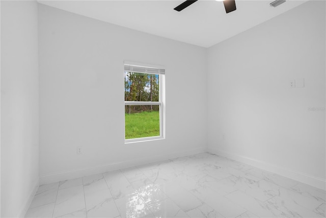 unfurnished room featuring light marble finish floors, baseboards, and a ceiling fan