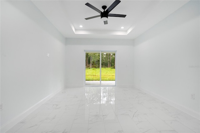 empty room with light marble finish flooring, a raised ceiling, baseboards, ceiling fan, and recessed lighting