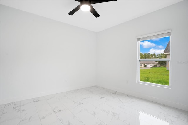unfurnished room featuring baseboards, marble finish floors, and ceiling fan