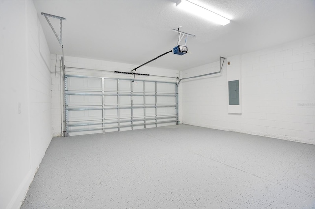 garage featuring concrete block wall, electric panel, and a garage door opener