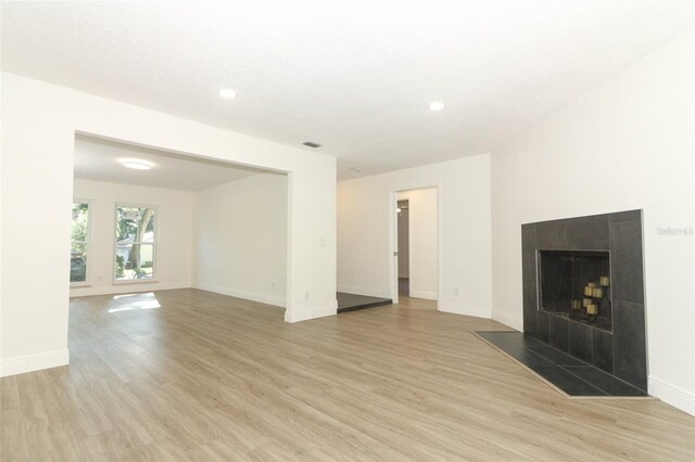 1204 Duncan Ct, Longwood, FL 32779 - unfurnished living room featuring light wood-style flooring, recessed lighting, and a tile fireplace