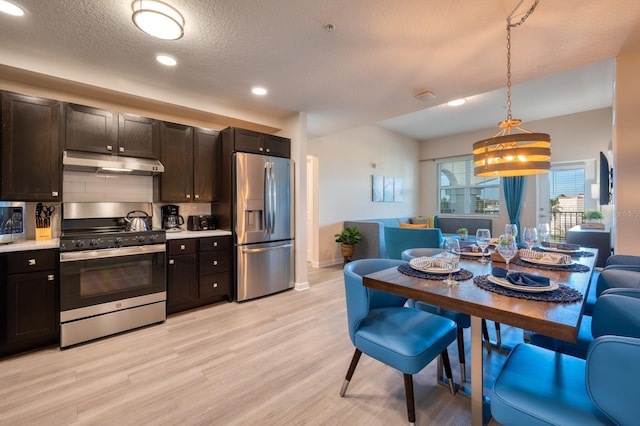 4013 Breakview Dr Unit A407, Orlando, FL 32819 - kitchen with appliances with stainless steel finishes, under cabinet range hood, tasteful backsplash, light wood-type flooring, and light countertops