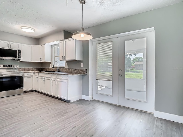 8228 Shriver Dr, Orlando, FL 32822 - kitchen featuring appliances with stainless steel finishes, a sink, dark countertops, a textured ceiling, and light wood finished floors