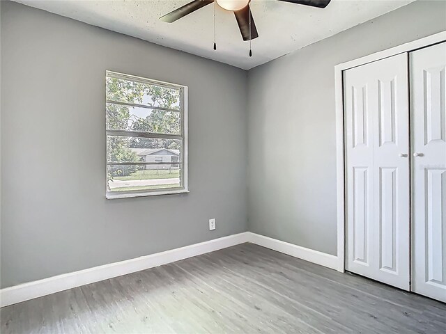 8228 Shriver Dr, Orlando, FL 32822 - unfurnished bedroom featuring baseboards, wood finished floors, a closet, and a ceiling fan