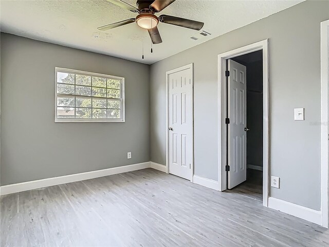 8228 Shriver Dr, Orlando, FL 32822 - unfurnished bedroom featuring wood finished floors, baseboards, a textured ceiling, and a ceiling fan