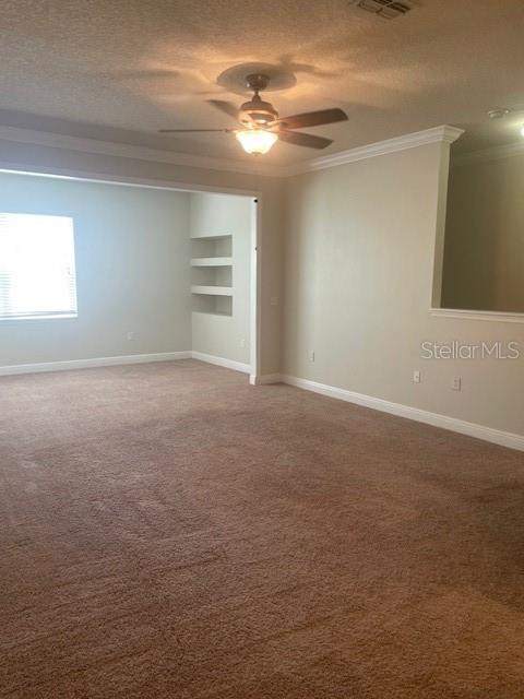 417 Southern Pecan Cir Unit 201, Winter Garden, FL 34787 - carpeted empty room with crown molding, a textured ceiling, a ceiling fan, baseboards, and built in shelves