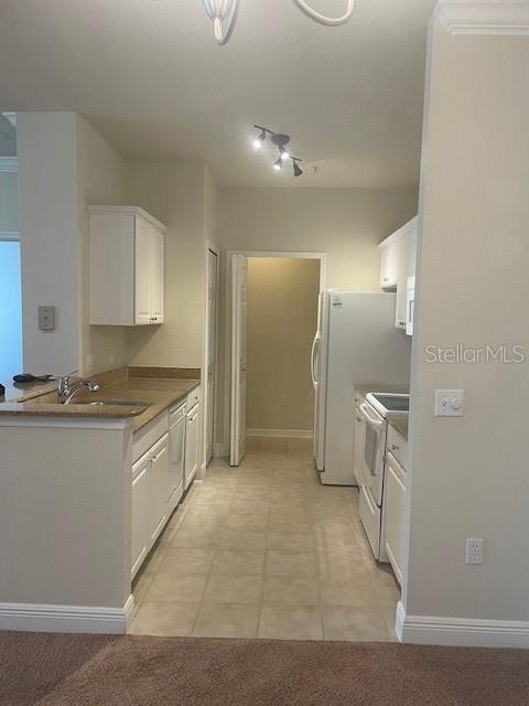 417 Southern Pecan Cir Unit 201, Winter Garden, FL 34787 - kitchen featuring white range with electric stovetop, a sink, white cabinets, stainless steel dishwasher, and baseboards