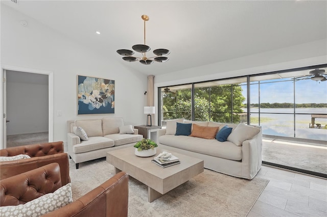 living area featuring a chandelier, a water view, and high vaulted ceiling