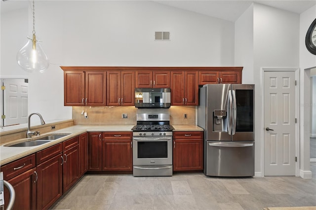 kitchen featuring stainless steel appliances, a sink, high vaulted ceiling, light countertops, and reddish brown cabinets