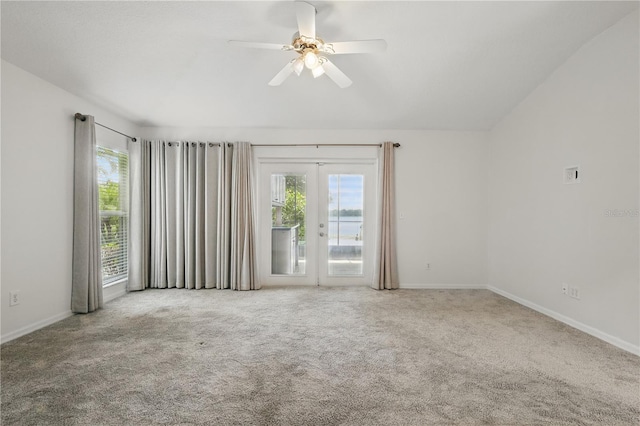 carpeted spare room featuring french doors, a ceiling fan, baseboards, and lofted ceiling