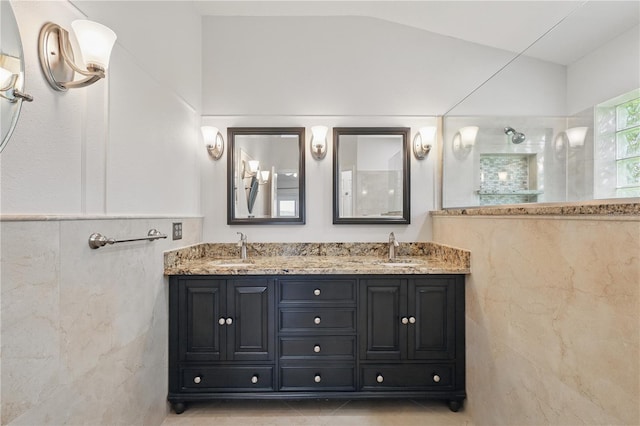 full bath featuring a walk in shower, double vanity, tile walls, and tile patterned floors