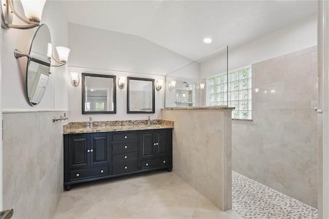 full bath with walk in shower, double vanity, lofted ceiling, and tile patterned floors