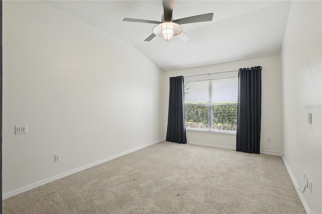 spare room featuring lofted ceiling, carpet floors, baseboards, and ceiling fan