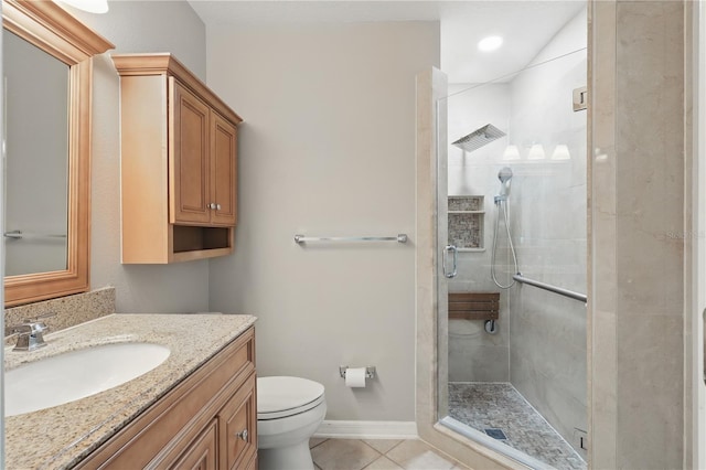 full bathroom with a shower stall, tile patterned floors, vanity, toilet, and baseboards