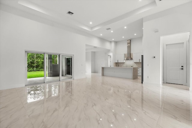 4528 Yorkshire Ln, Kissimmee, FL 34758 - unfurnished living room with a high ceiling, a raised ceiling, light marble finish floors, and recessed lighting