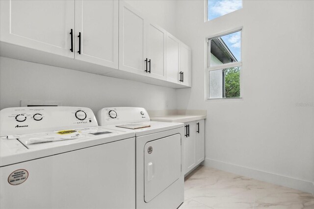 4528 Yorkshire Ln, Kissimmee, FL 34758 - laundry room with light marble finish flooring, washer and clothes dryer, cabinet space, and baseboards
