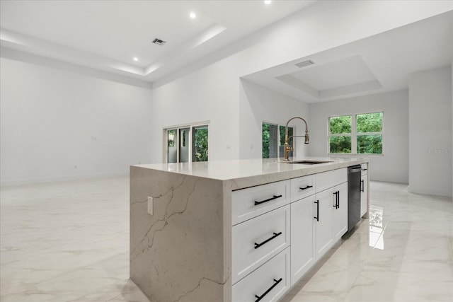 4528 Yorkshire Ln, Kissimmee, FL 34758 - kitchen featuring a tray ceiling, a sink, light stone counters, stainless steel dishwasher, and an island with sink