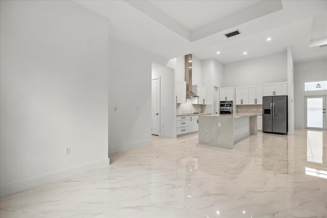 4528 Yorkshire Ln, Kissimmee, FL 34758 - kitchen with stainless steel appliances, a towering ceiling, wall chimney range hood, light marble finish flooring, and baseboards