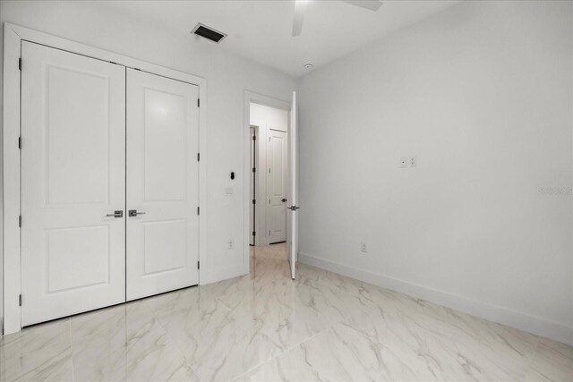 4528 Yorkshire Ln, Kissimmee, FL 34758 - unfurnished bedroom with marble look tile flooring, a closet, baseboards, and a ceiling fan
