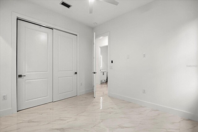 4528 Yorkshire Ln, Kissimmee, FL 34758 - unfurnished bedroom with light marble finish floors, baseboards, a closet, and a ceiling fan