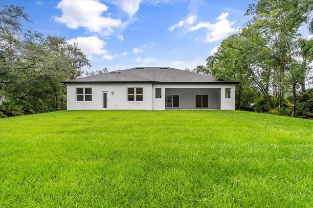 4528 Yorkshire Ln, Kissimmee, FL 34758 - rear view of house featuring stucco siding, a lawn, and roof with shingles