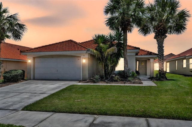 mediterranean / spanish-style house with a tiled roof, stucco siding, and driveway