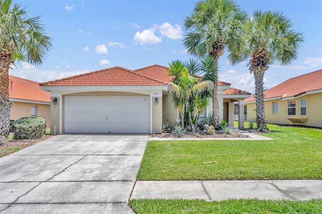mediterranean / spanish-style house featuring a tile roof, stucco siding, concrete driveway, a front yard, and a garage